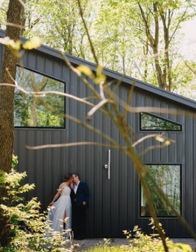 Bride and groom posing for wedding photo outside cabin in the woods at Retreat 21 near Columbus, Ohio